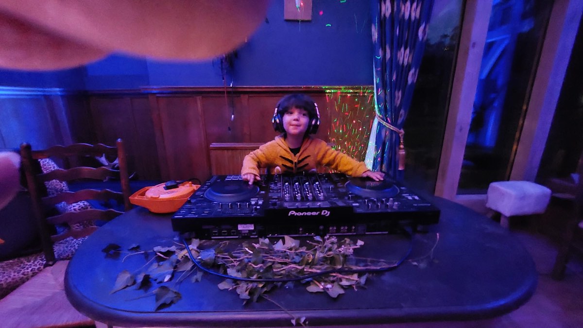 A young DJ at the decks in the rave room